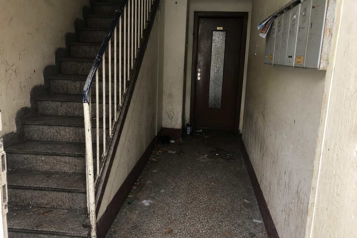 Verschmutztes Treppenhaus mit sichtbarem Schmutz auf Stufen und Geländer